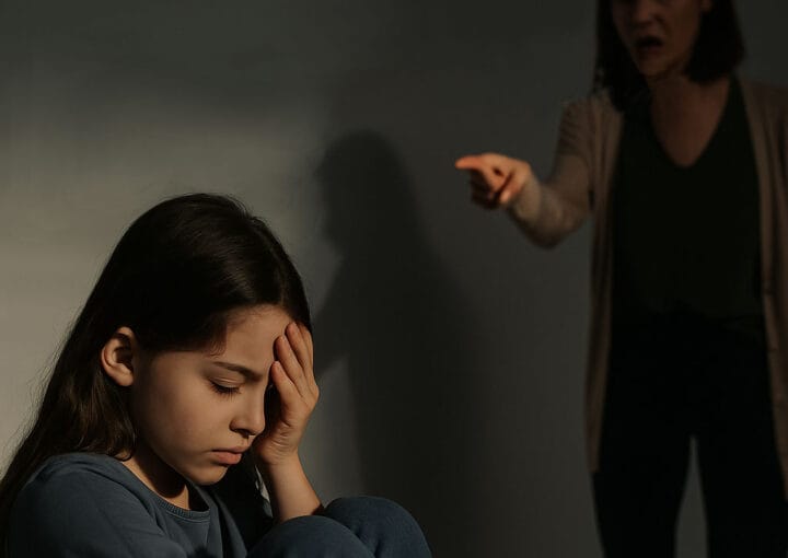 Criarse con una Madre Emocionalmente Inestable: Una niña pequeña emocionalmente destrozada frente a su madre que le grita.