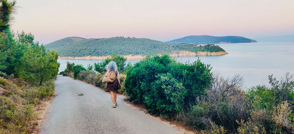 Loneliness 1 A woman walking alone in nature, symbolising facing loneliness, showing self-compassion, and connecting with the Soul Family through Reiki.