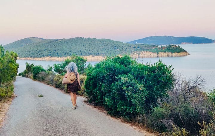 Una mujer caminando sola en la naturaleza, simbolizando enfrentar la soledad, mostrar autocompasión y conectar con la Familia del Alma a través del Reiki.