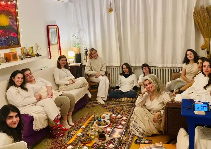 winter solstice ceremony reiki circle group sitting around candles.