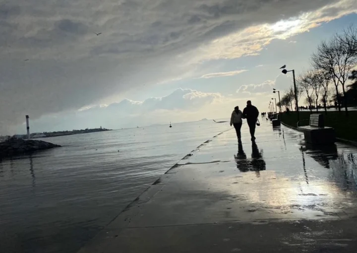 two people walking by the sea with light reflections symbolizing inner light and spiritual journey