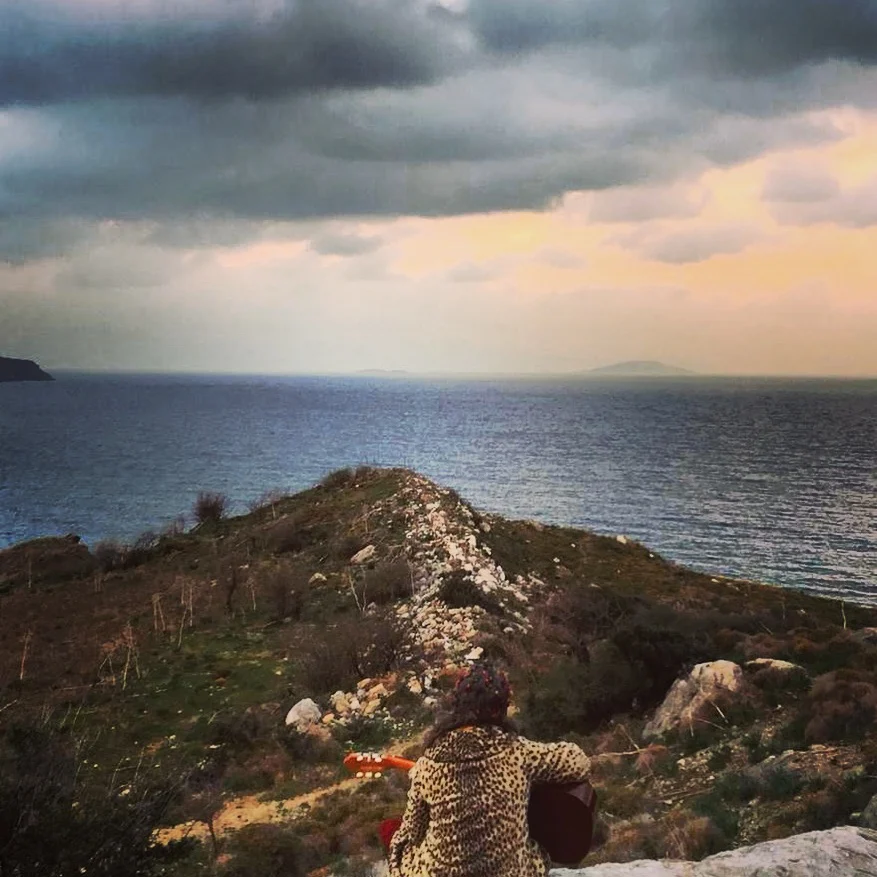Hande Özerden deniz kenarında ufka karşı gitar çalarken, sesin ve niyetin sonsuzluğa uzanışı.