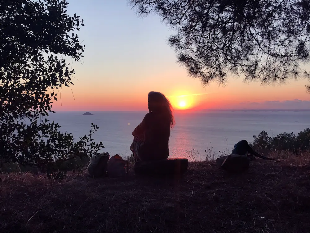 Reiki uzmanı Hande Özerden doğada güneşe doğru oturmuş uzaktan Reiki gönderirken.
