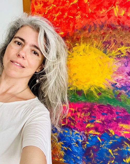 Retrato frente a una pintura, la creatividad liberada con Reiki.