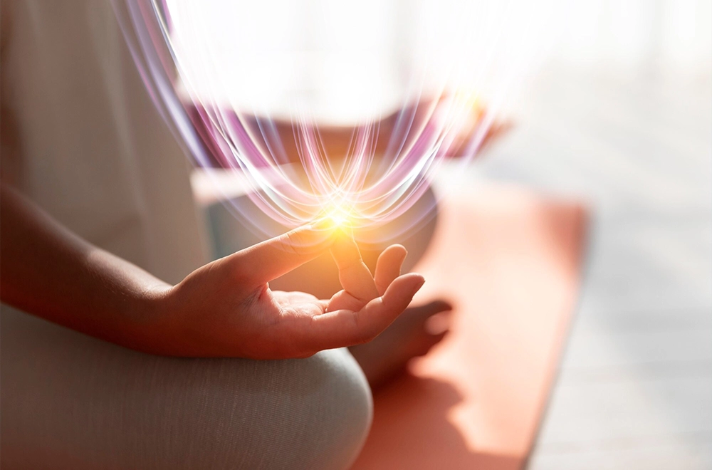 Hands holding a glowing light symbolising subconscious healing with Reiki.